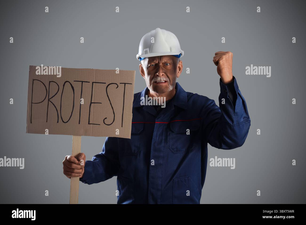 Protesting miner man with placard on grey background Stock Photo