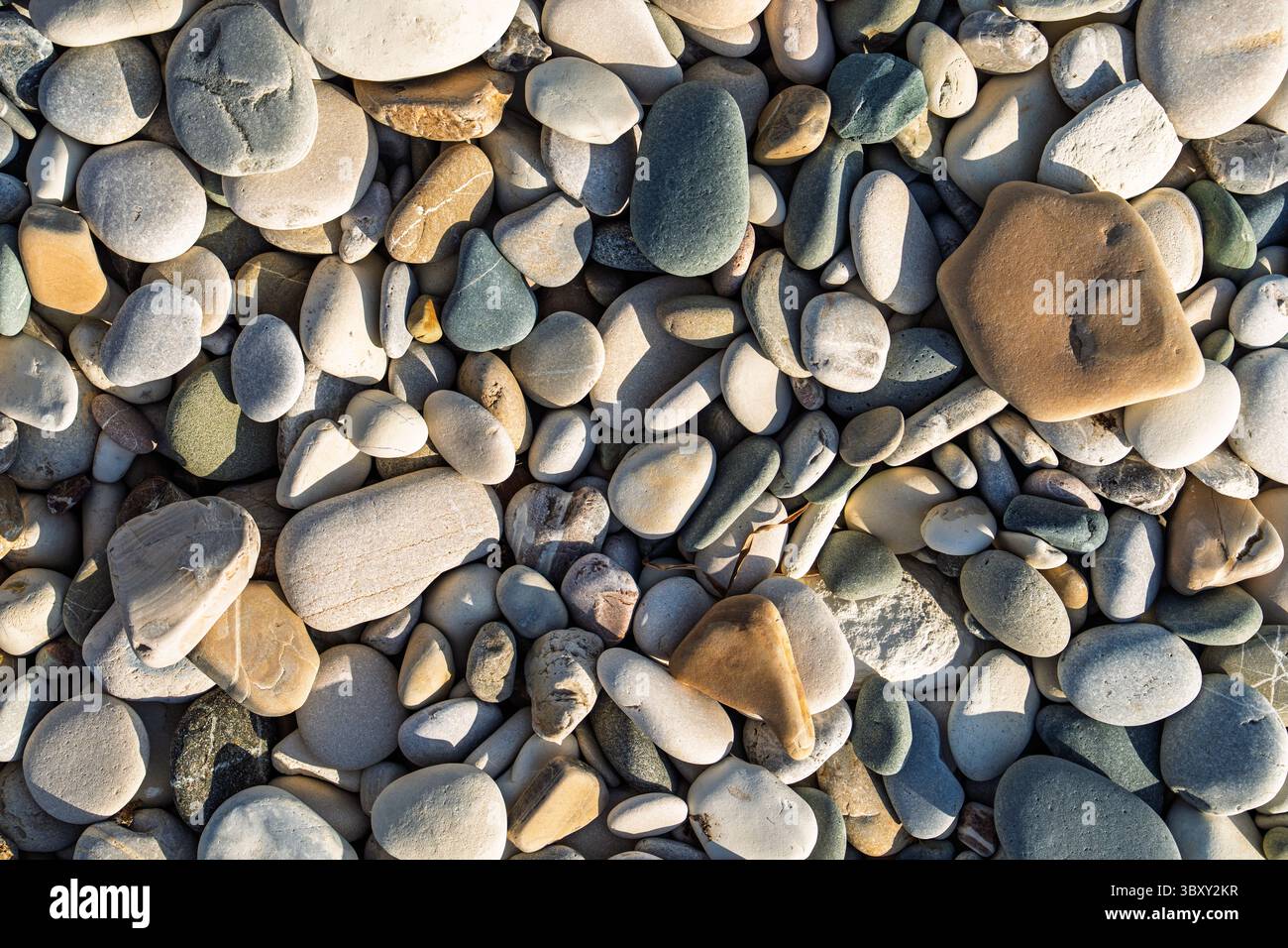 Smooth Beach Pebbles Texture, Natural Stone Background. A Calming Coastal Scene. Stock Photo