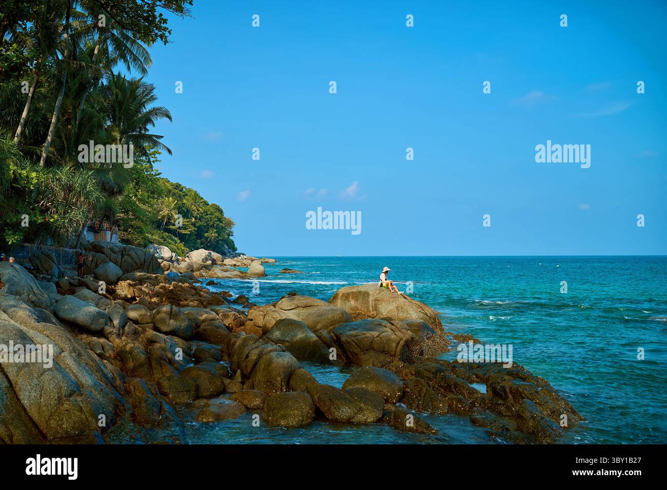 a man is fishing on the rocks by the sea Stock Photo - Alamy
