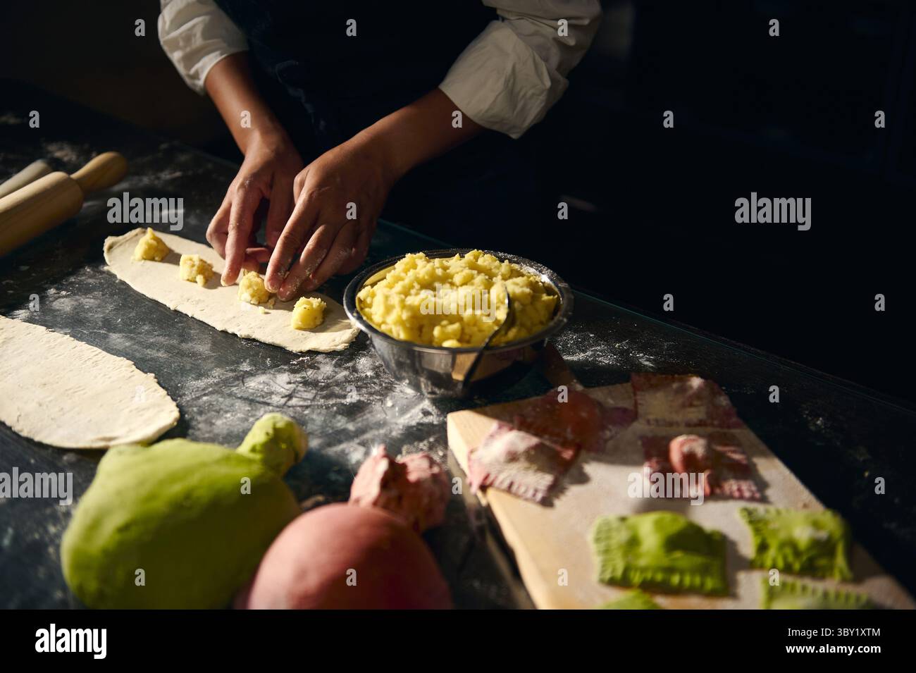 A chef crafts traditional ravioli using tri-colored dough and a potato ...