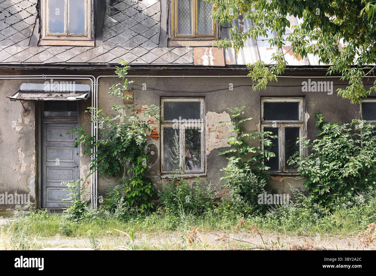 Old abandoned house wall. Weathered facade with broken windows and ...