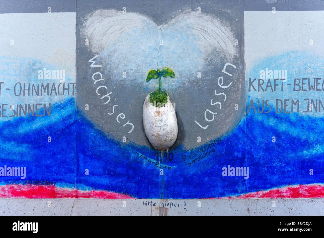 Berlin, Germany - May 30, 2025: Close-up of a Berlin Wall mural depicting a  heart-shaped planter with a plant, surrounded by vibrant colors and inspir  Stock Photo - Alamy