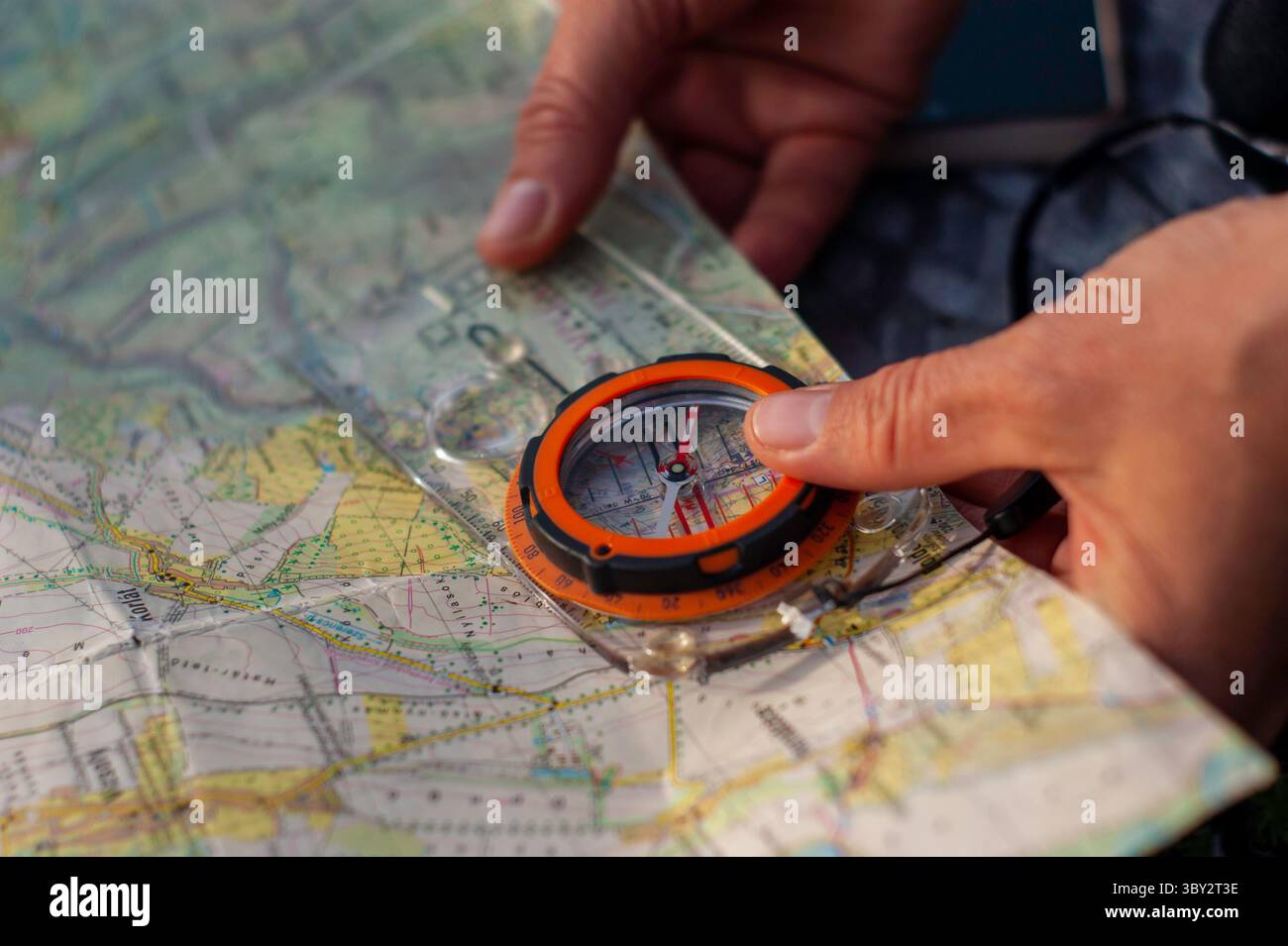 Hands Navigating Using a Compass and Map in an Outdoor Adventure Setting Stock Photo