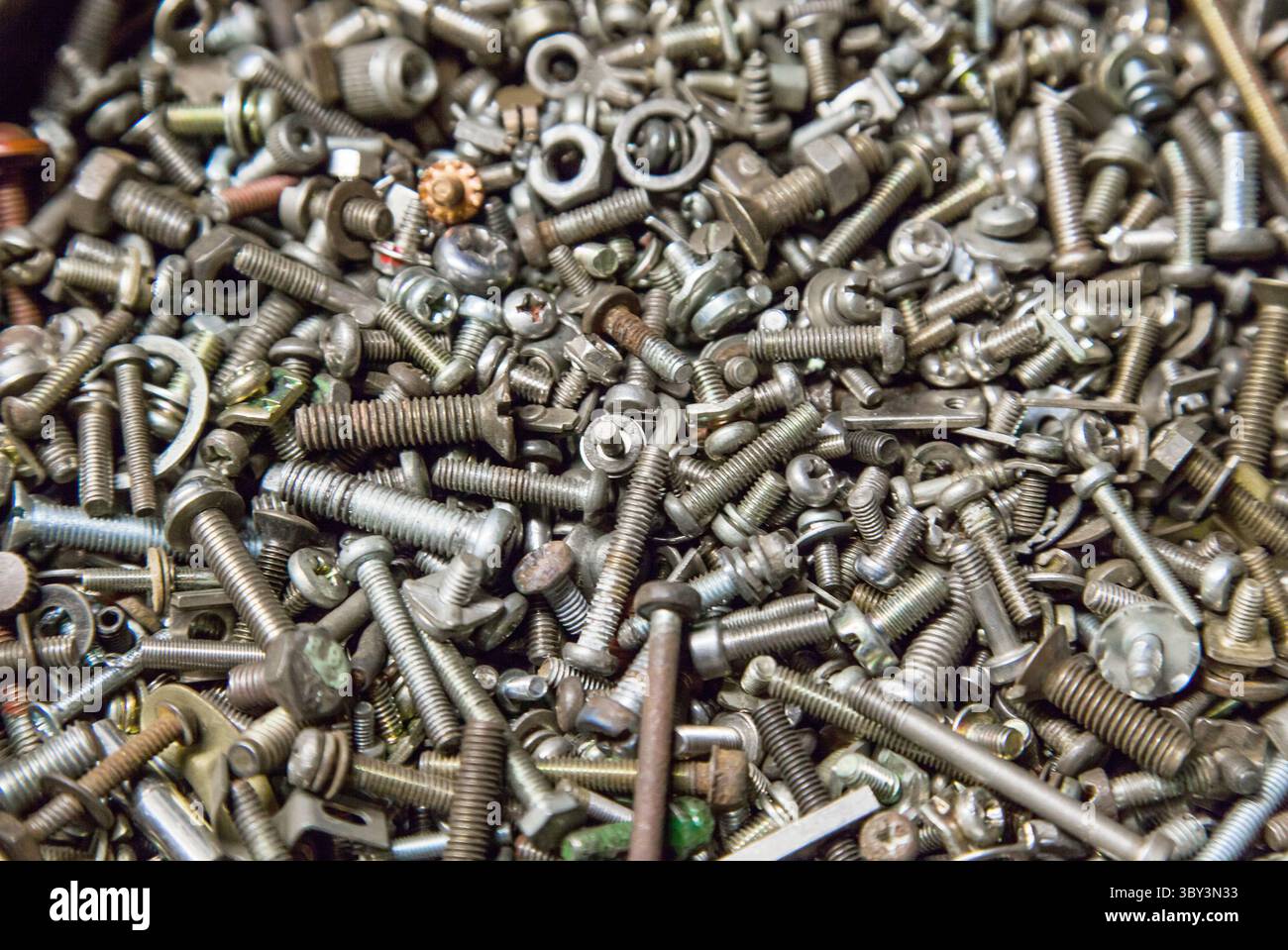 Many different small bolts, nuts, washers, grovers, studs and screws. Technical background. Industrial texture. Stock Photo