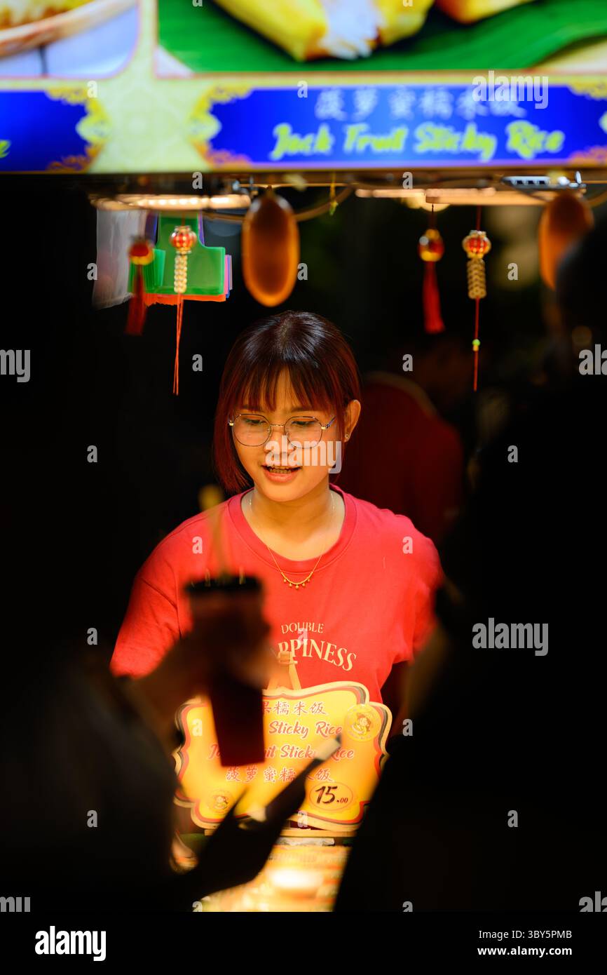Girl selling street food on Jalan Alor food street, Bukit Bintang, Kuala Lumpur, Malaysia Stock Photo