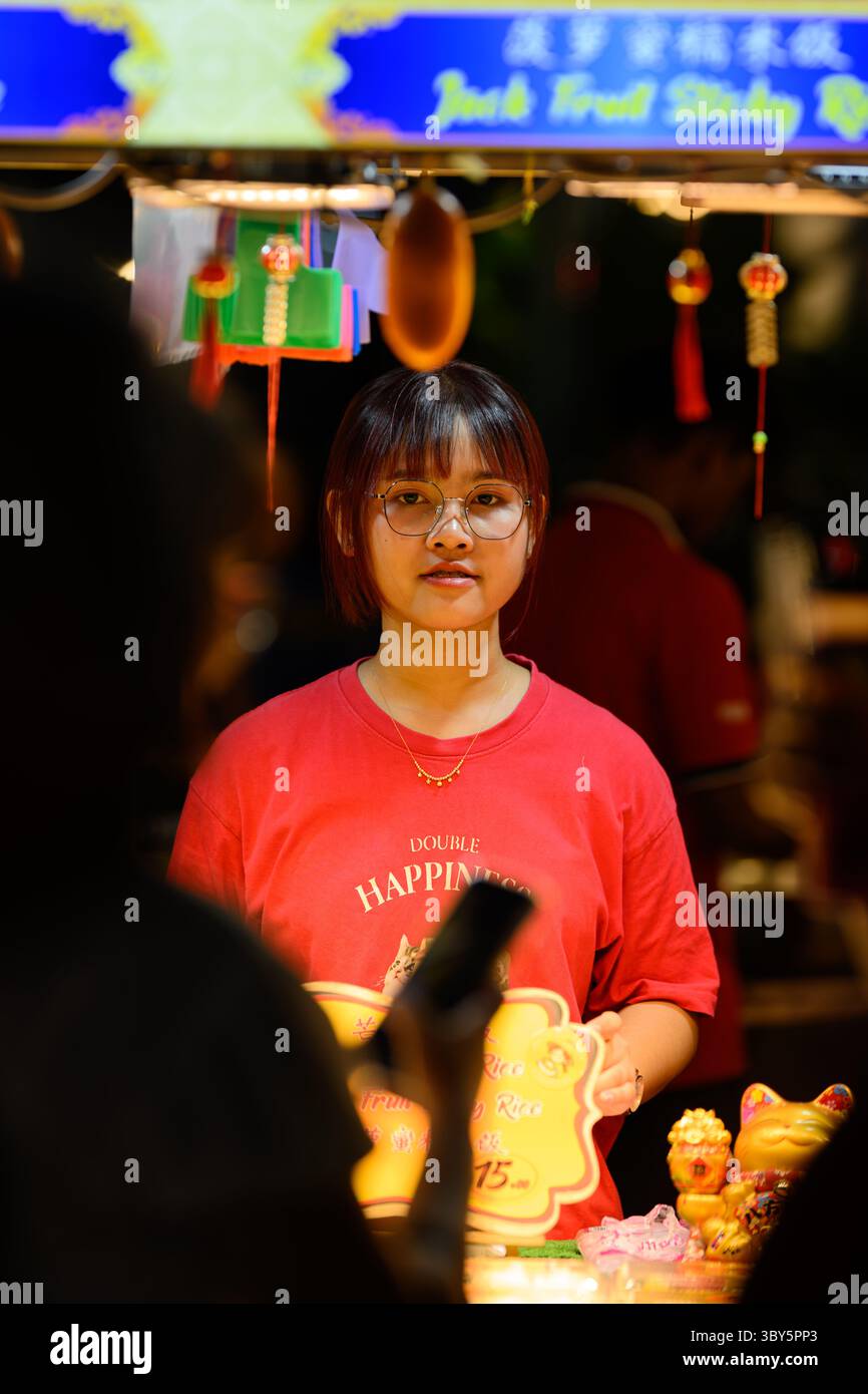 Girl selling street food on Jalan Alor food street, Bukit Bintang, Kuala Lumpur, Malaysia Stock Photo