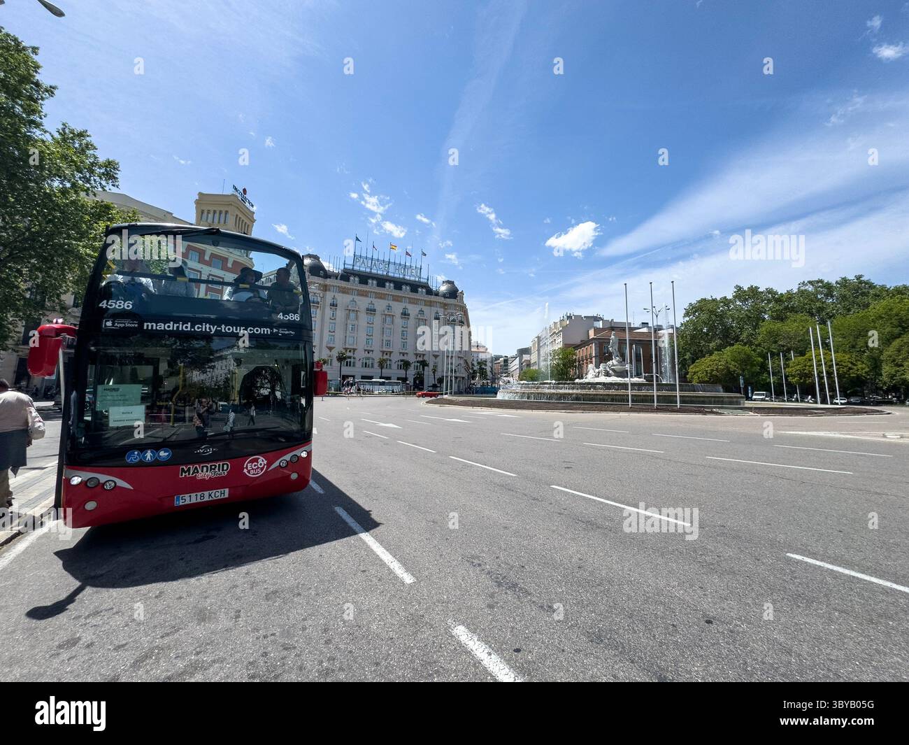 City Tour bus, Fuente de Neptuno in Plaza de Cánovas del Castillo (commonly called Plaza de Neptuno), on Paseo del Prado, Madrid, Spain - Smartphone Captured Stock Image
