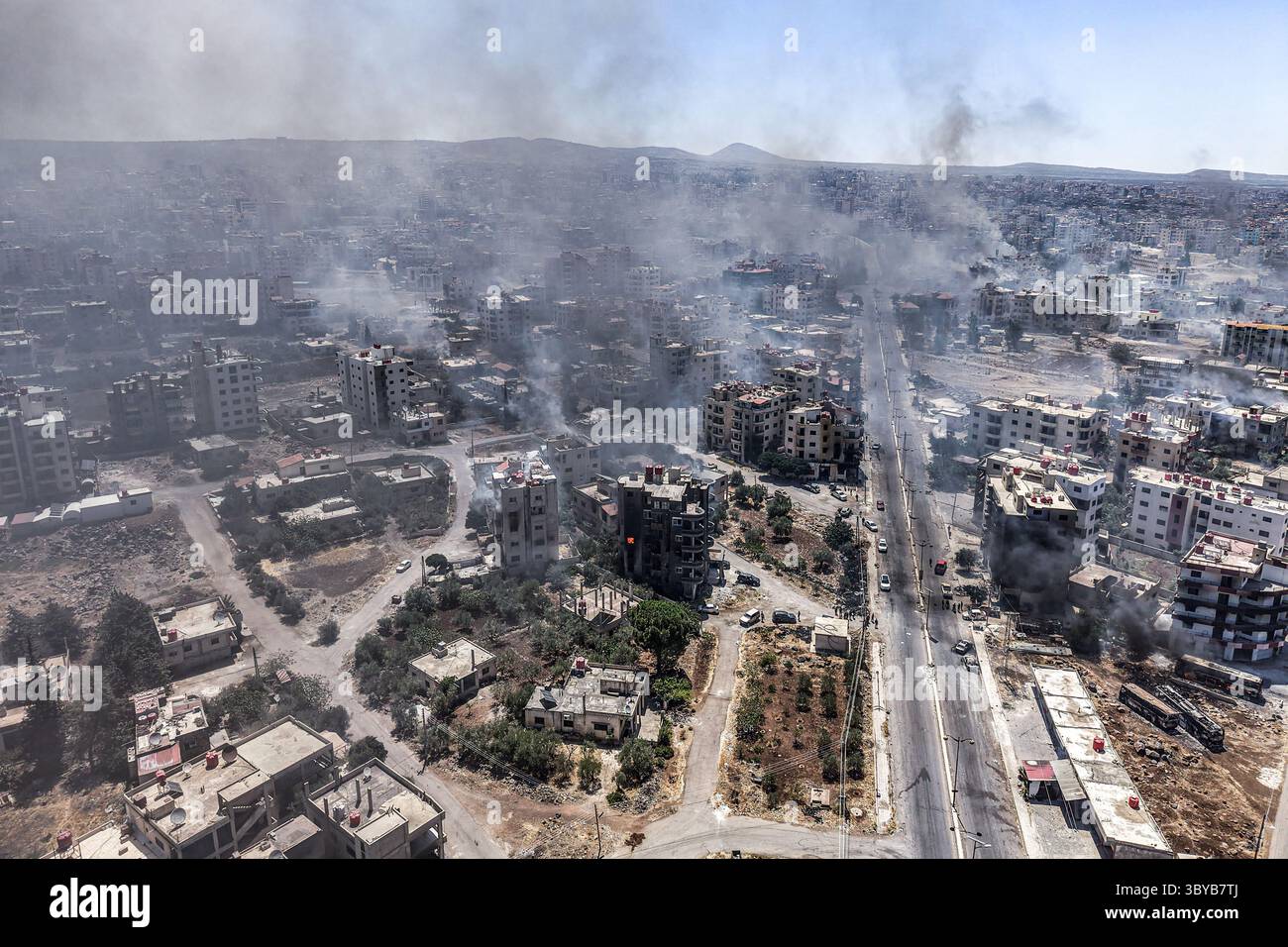 As Suwayda, Syria. 19th July, 2025. An aerial view shows the city of As Suwayda, with smoke rising from burning houses amid clashes between tribal fighters and local Druze factions in southern Syria. Fear and shock grip the province following the escalation of isolated clashes into one of the deadliest outbreaks of violence the region has seen in years. Credit: Moawia Atrash/dpa/Alamy Live News Stock Photo