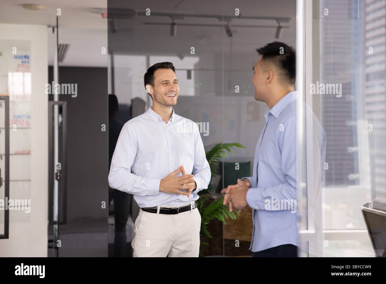 Two men standing and talking in modern office Stock Photo