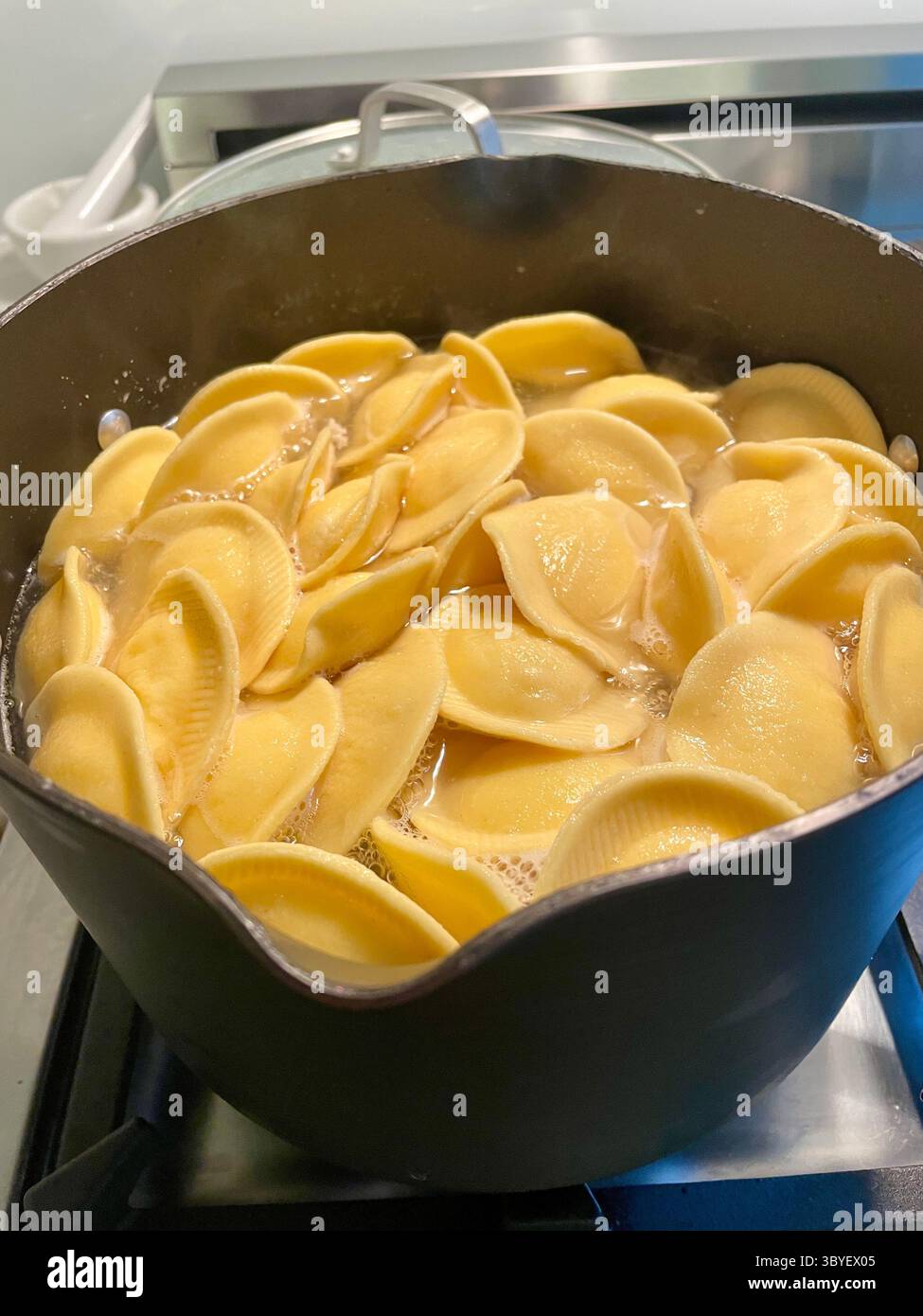 Fresh ravioli cooking on a residential gas stove top, 2025, United States - Smartphone Captured Stock Image
