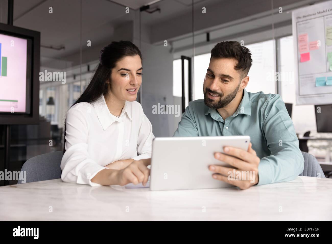Two Latin teammates working on joint task using digital tablet Stock Photo