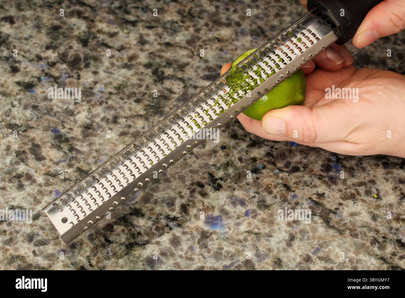 Close-Up of Fresh Lime Being Zested with a Microplane Stock Photo