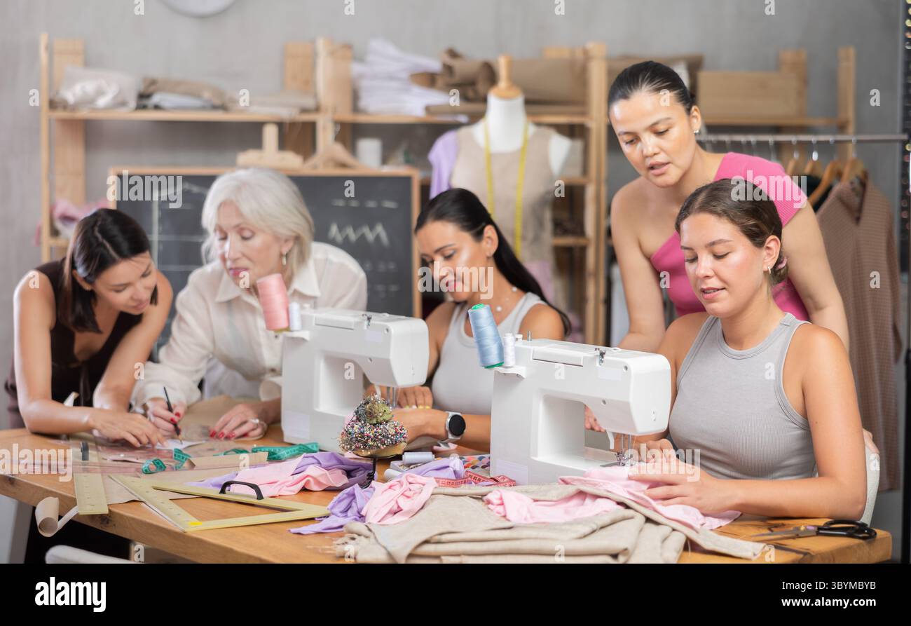 Group of women sew and draw pattern at sewing workshop Stock Photo - Alamy