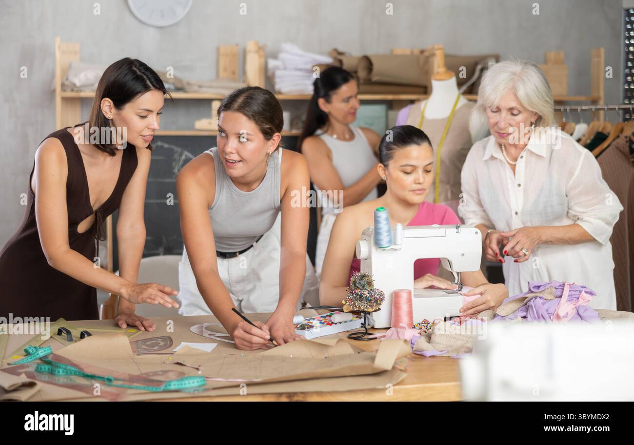 Group of women sew, draw pattern and work with mannequin Stock Photo ...