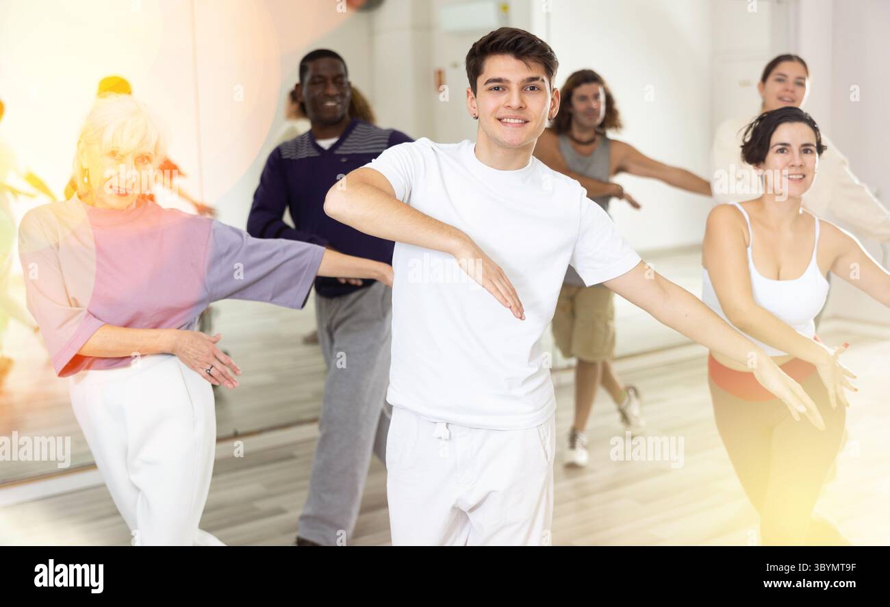 Cheerful guy practicing modern vigorous dance with group Stock Photo