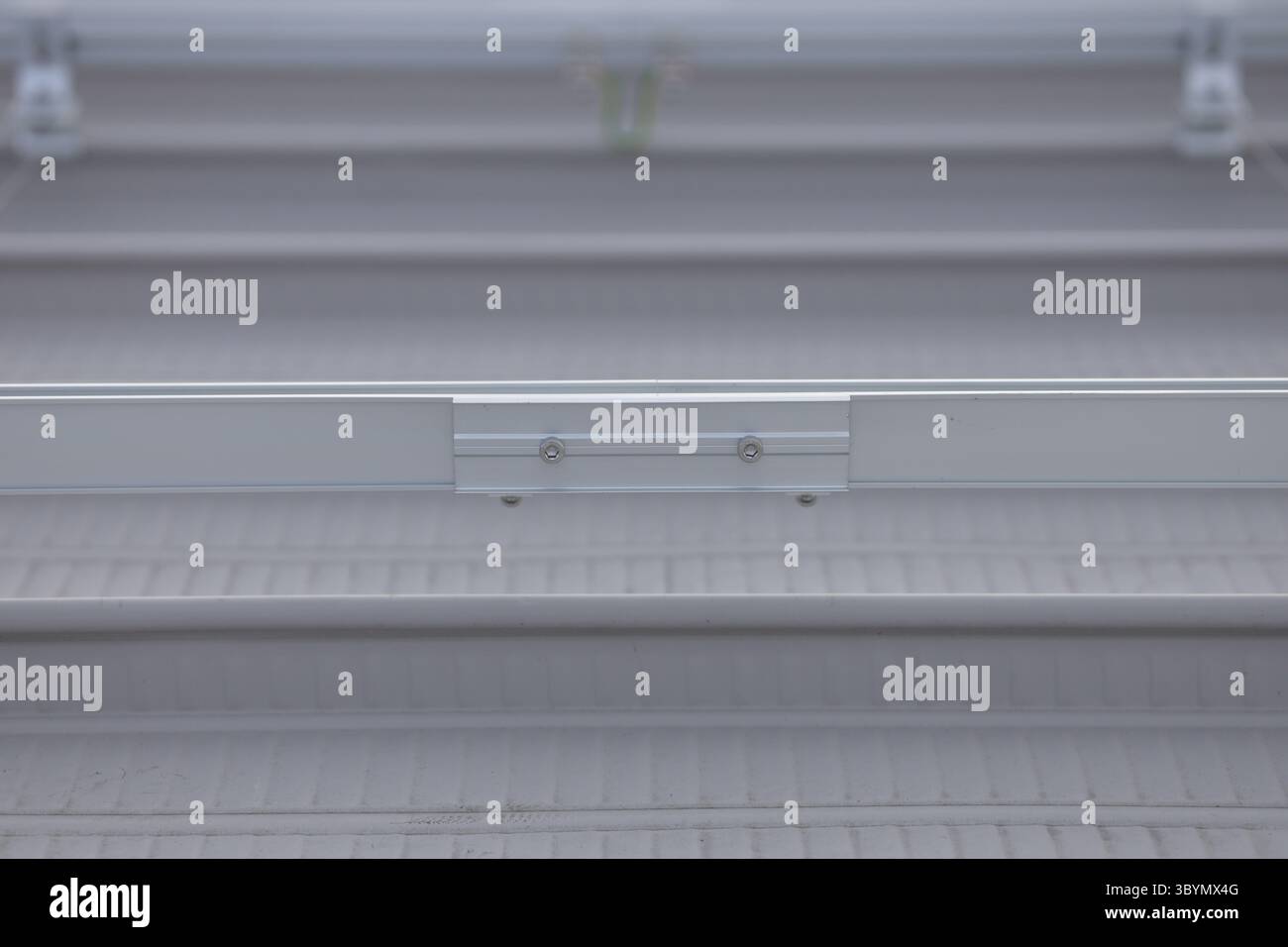 The connection point of two rail sections. Rail splice tighten with nuts connecting two rail sections. Rail for supporting solar panels. Stock Photo