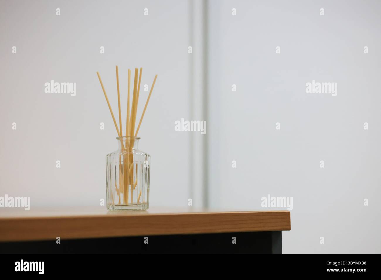 Reed diffusers in perfume bottles are placed on the table. Reed diffusers help create a good atmosphere for a place. Stock Photo