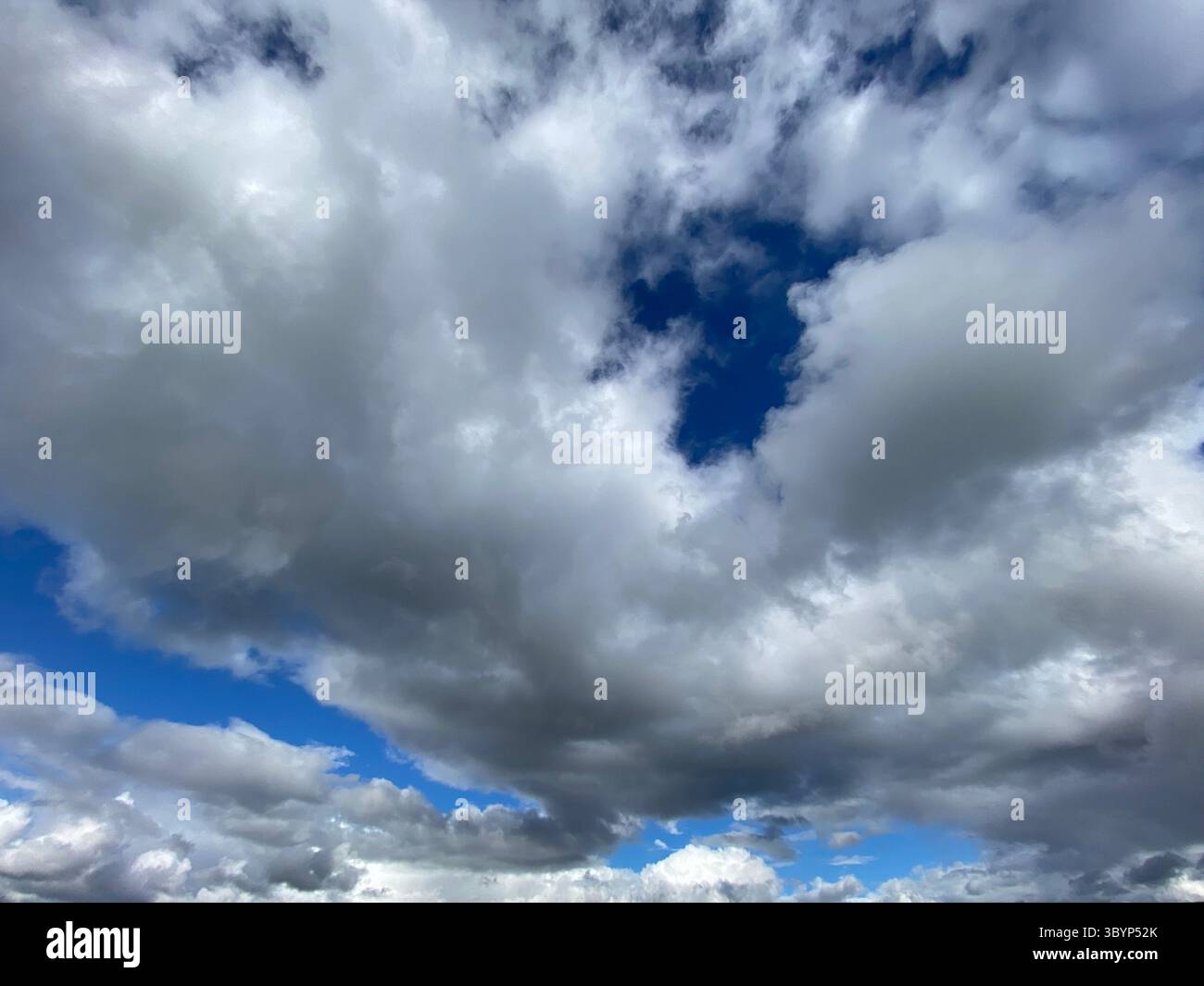 Spectacular view of a bright blue sky filled with billowing clouds. - Smartphone Captured Stock Image
