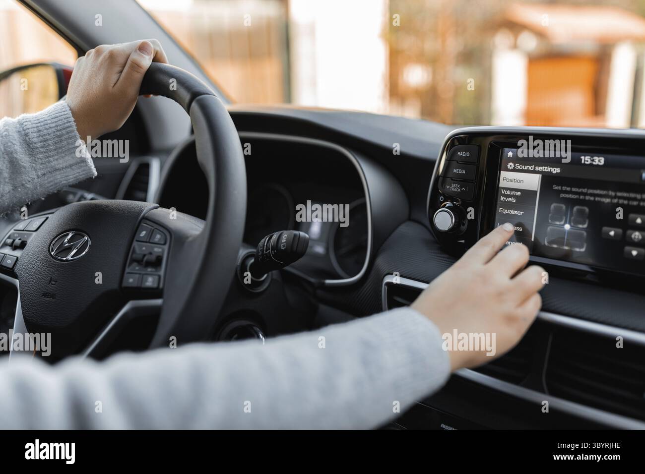 Adjusting Language with touchscreen of a modern car. Driving at a sunny ...