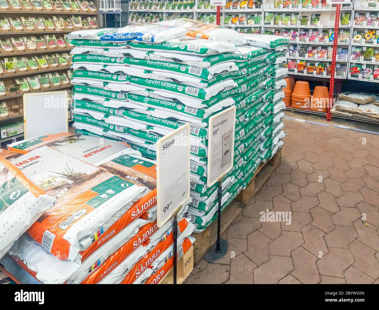 Porsgrunn, Norway - April 06, 2025: Gardening supplies arranged in a shop featuring colorful bags of soil and terracotta pots, creating an inviting at Stock Photo
