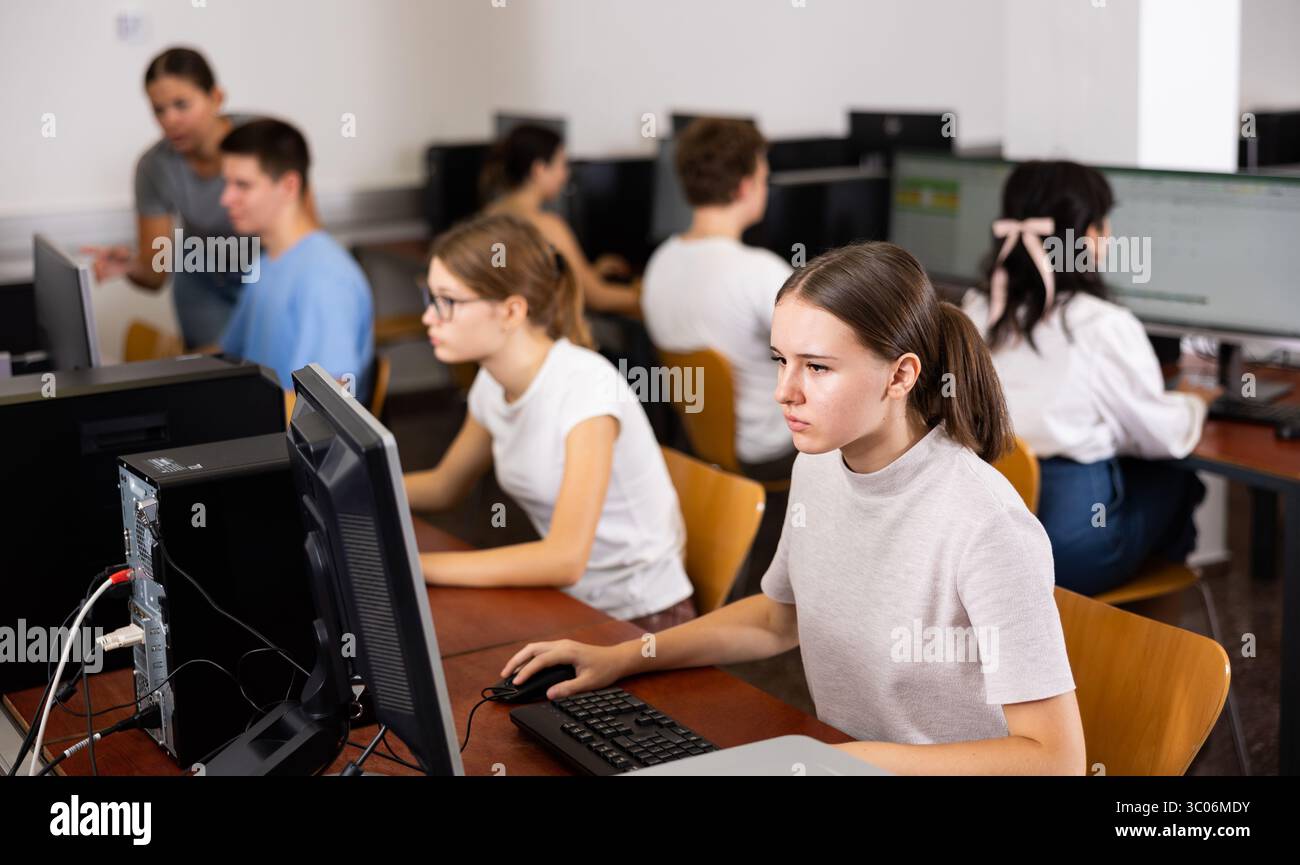 Portrait of interested teen girl during lesson in computer room of ...