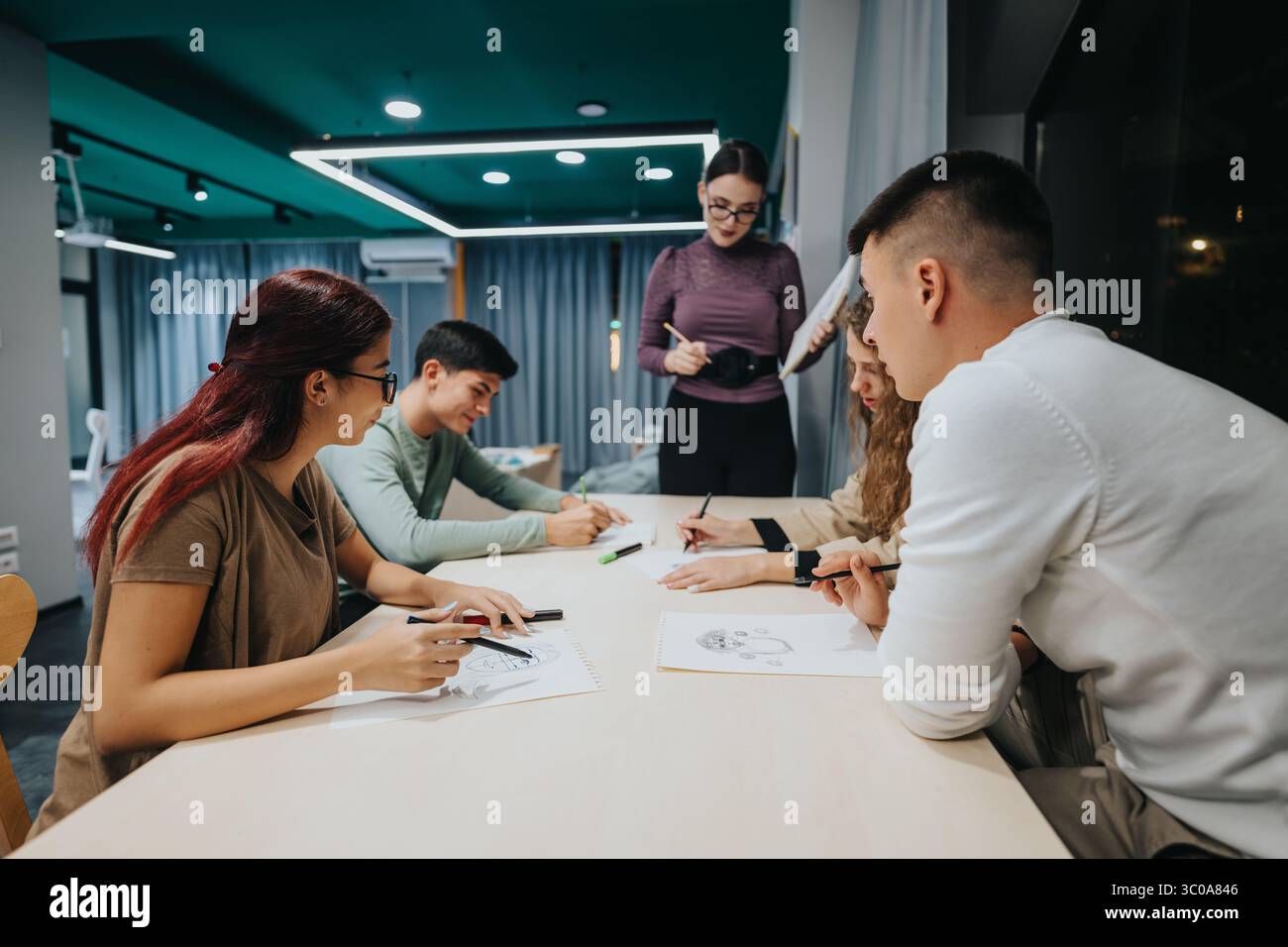 Group of students collaborating in a modern classroom setting Stock Photo