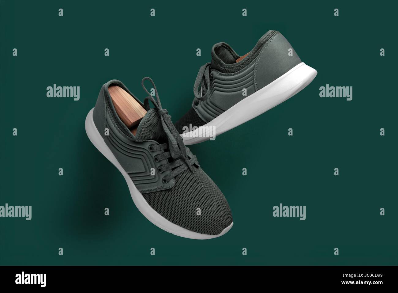 Stylish pair of green athletic sneakers with white soles, photographed from the top on a matching green background. The shoes feature mesh fabric and Stock Photo