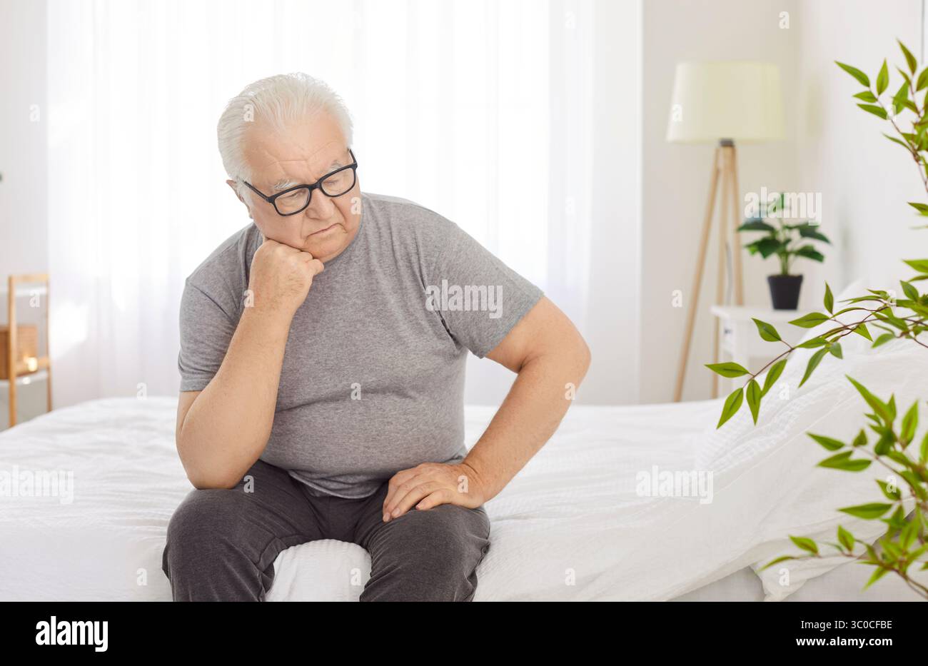 Sad Senior Man Reflecting In Bedroom At Home In The Morning Stock Photo ...