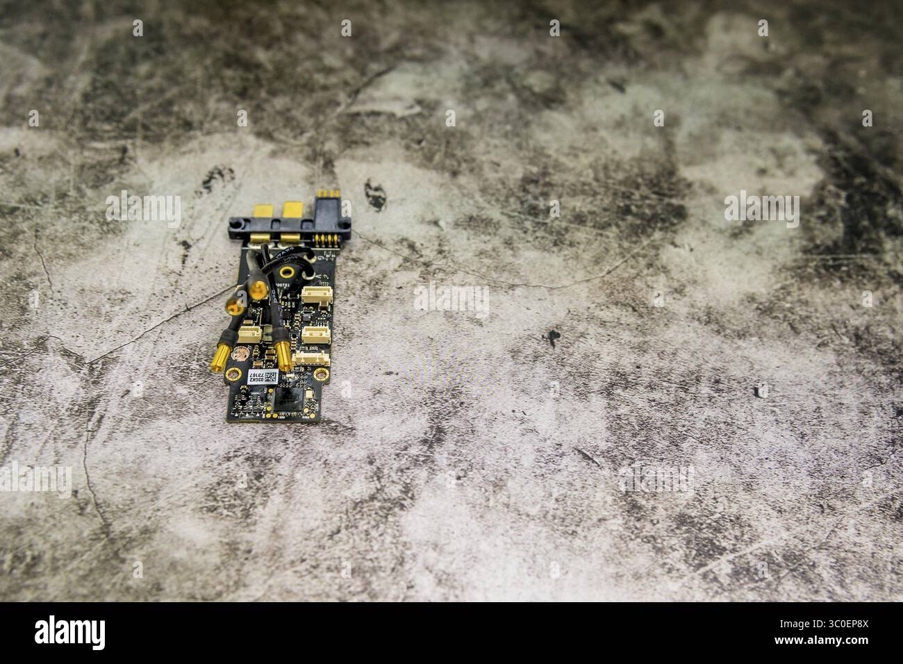 Small circuit board with various components on a textured backdrop for an abstract effect Stock Photo