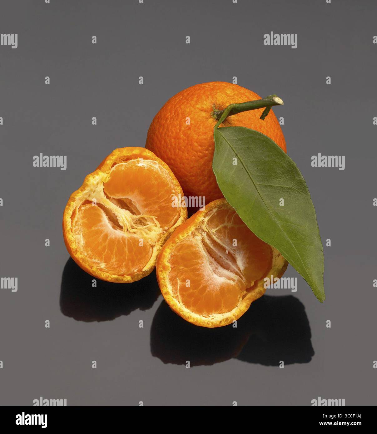 Vivid orange tangerine on black reflective surface Stock Photo