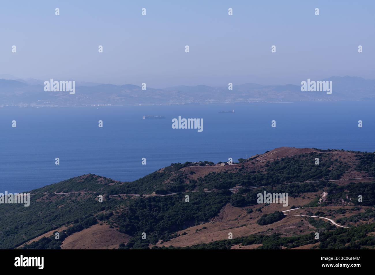 Cargo ships sailing on the strait of gibraltar, a narrow waterway separating europe and africa, symbolizing international trade and maritime transport Stock Photo