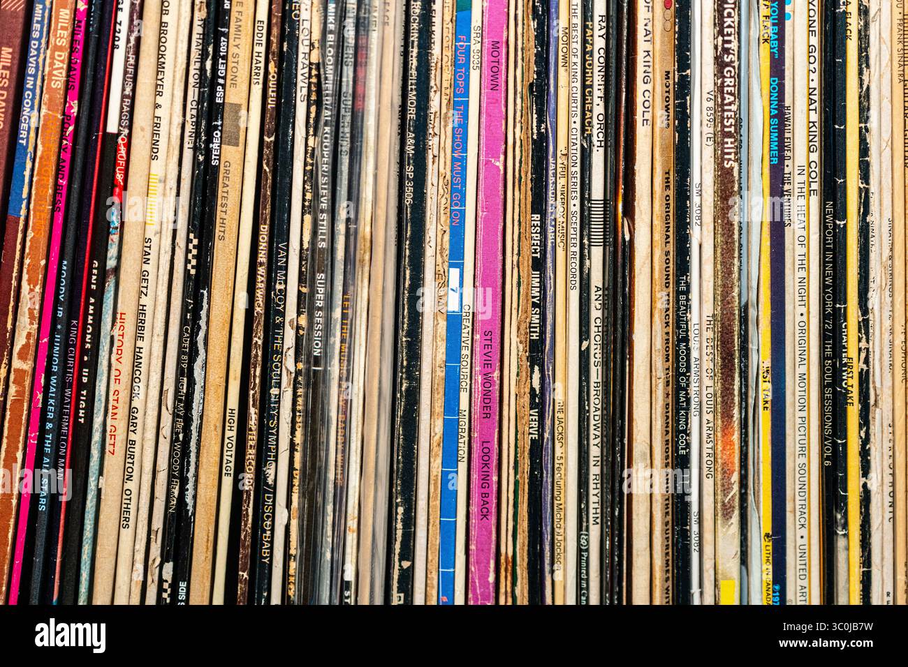 Collection of vintage vinyl records sleeves tightly stacked on a shelf ...
