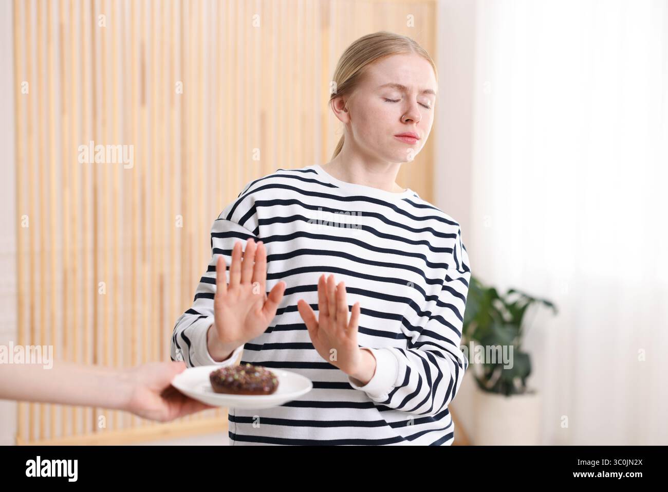 Gluten free diet. Woman refusing from donut indoors Stock Photo - Alamy