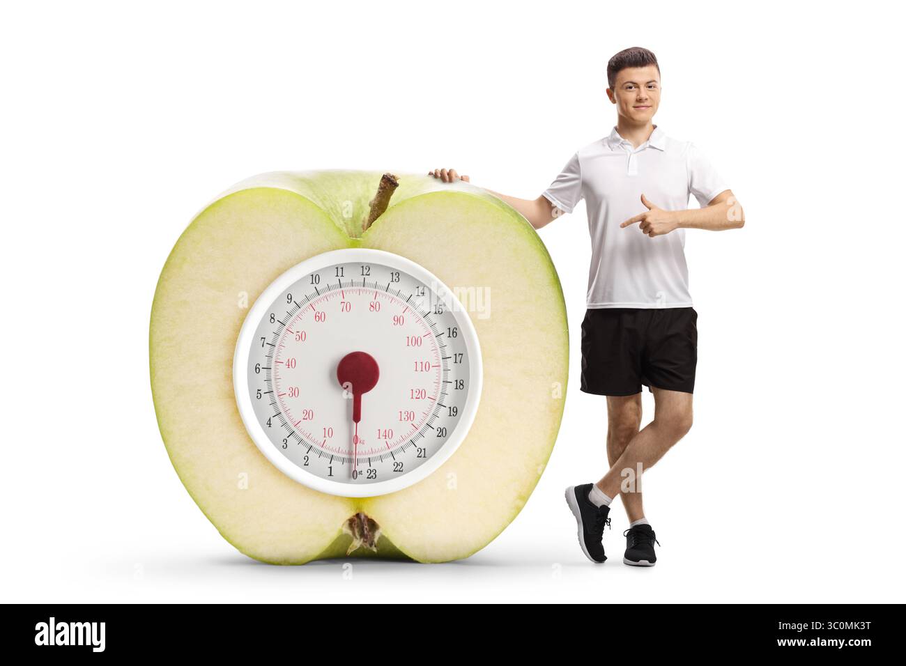 Full length portrait of a young man pointing at a big apple with a weight scale isolated on white background Stock Photo