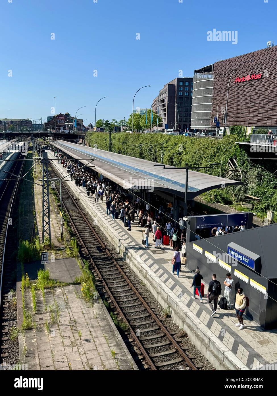 Crowded platform at Hamburg central train station (Hauptbahnhof) in Germany, with passengers waiting for the train on a sunny day. - Smartphone Captured Stock Image