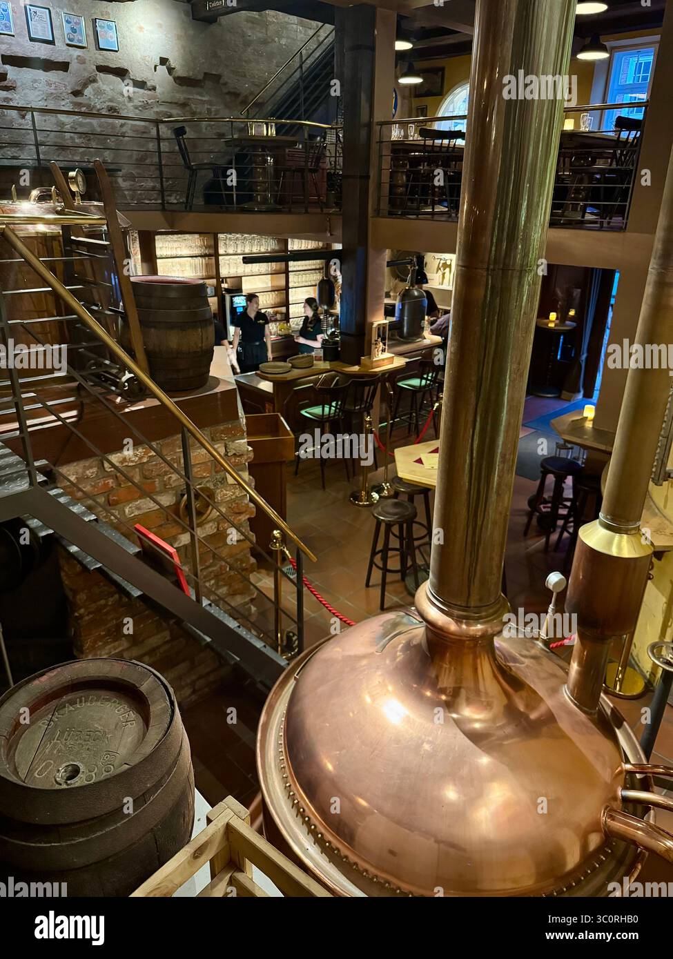 Interior of a traditional brewery pub in Lübeck, Germany, showcasing copper brewing tanks and rustic design. - Smartphone Captured Stock Image