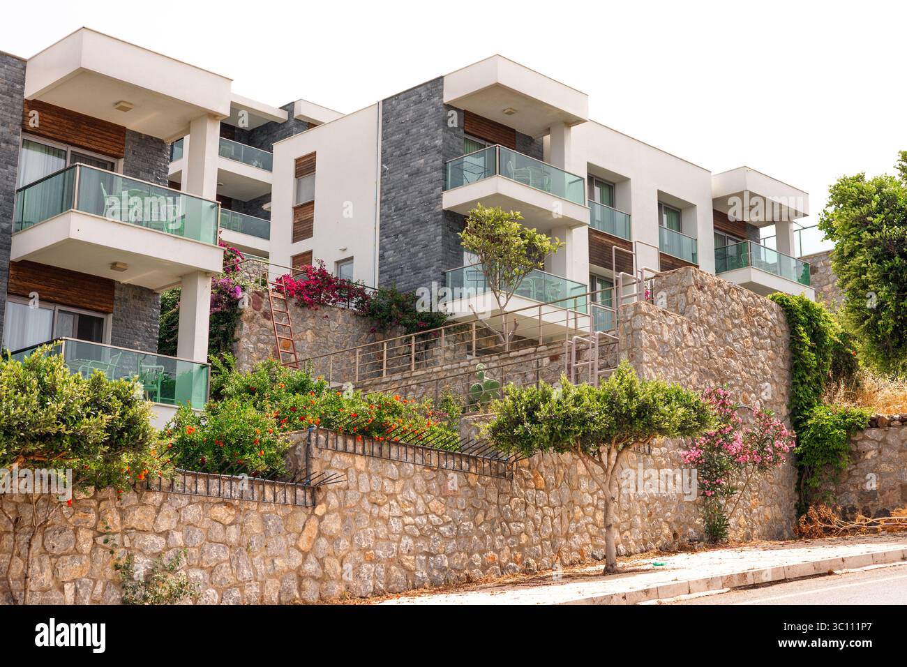 Modern apartment building with balconies and greenery. The structure ...