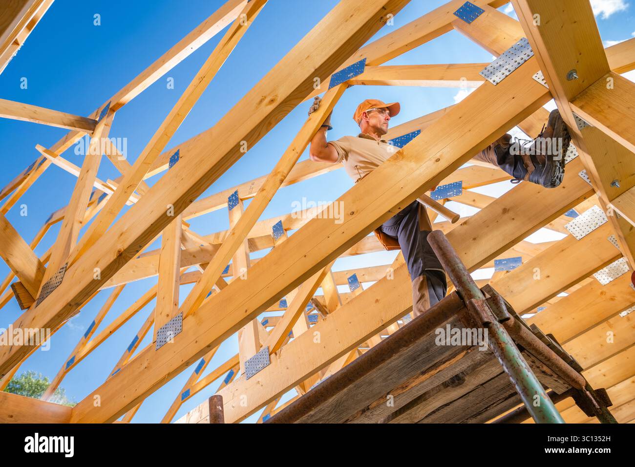 A construction worker skillfully navigates wooden beams while working ...