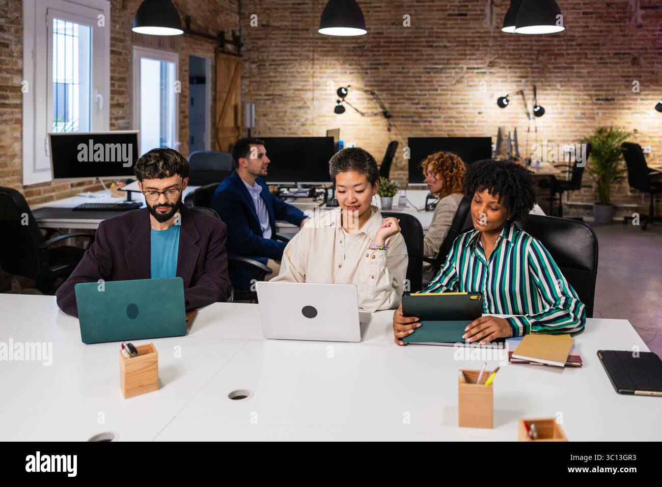 Multi ethnic team collaborating on project in modern office Stock Photo