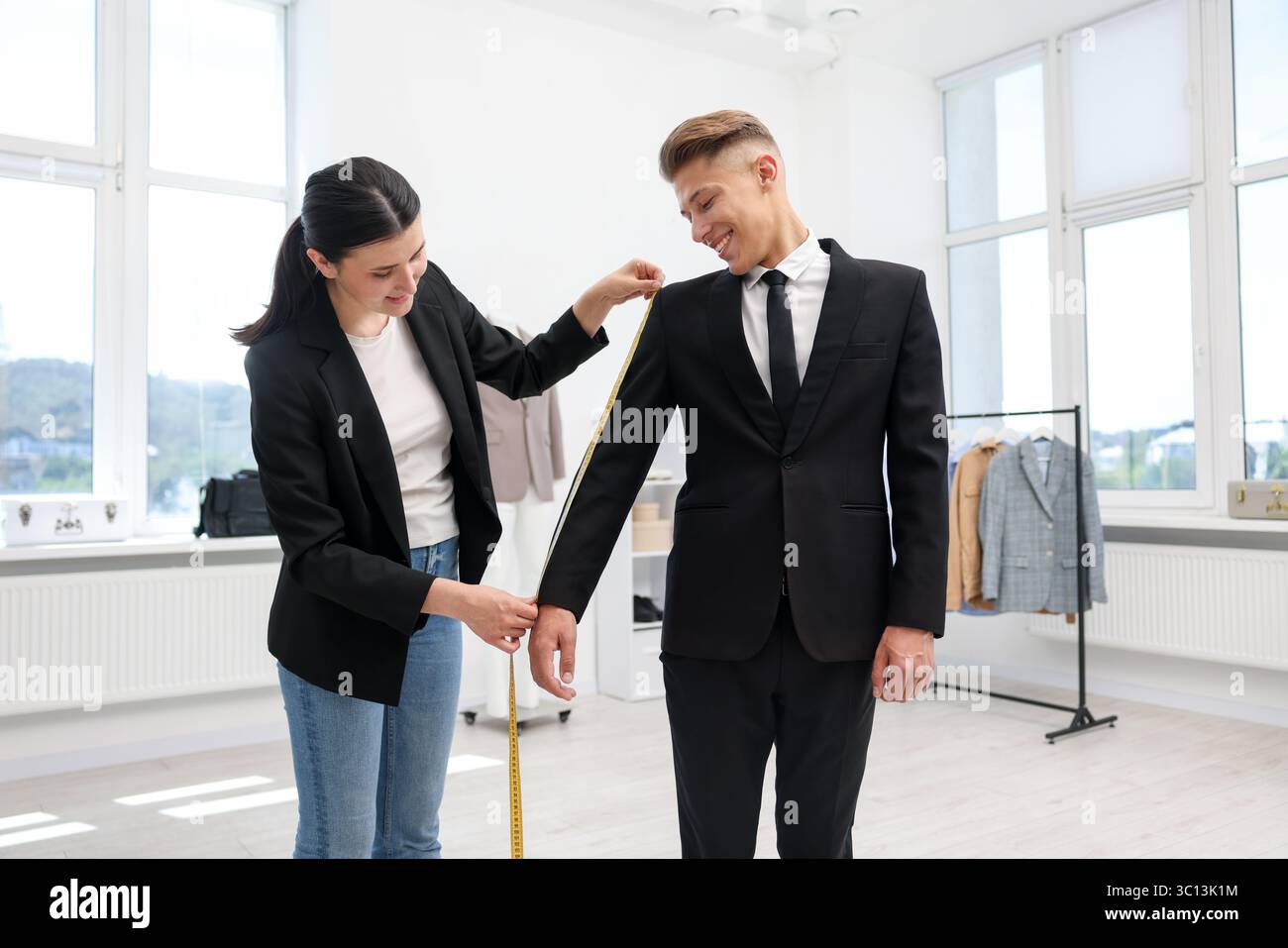 Tailor measuring jacket on man in atelier Stock Photo