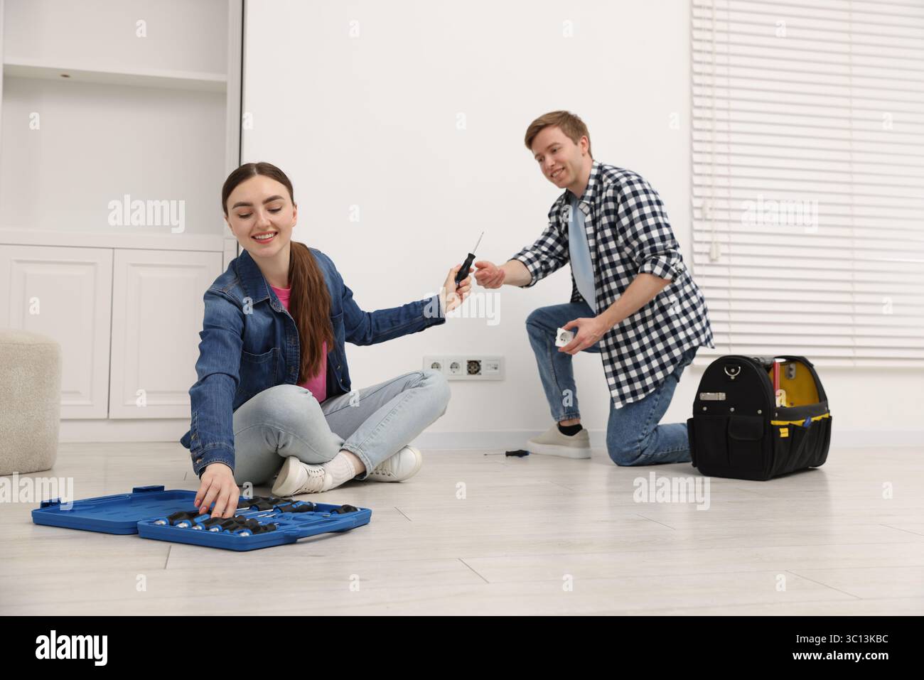 Couple with tools installing new socket at home Stock Photo