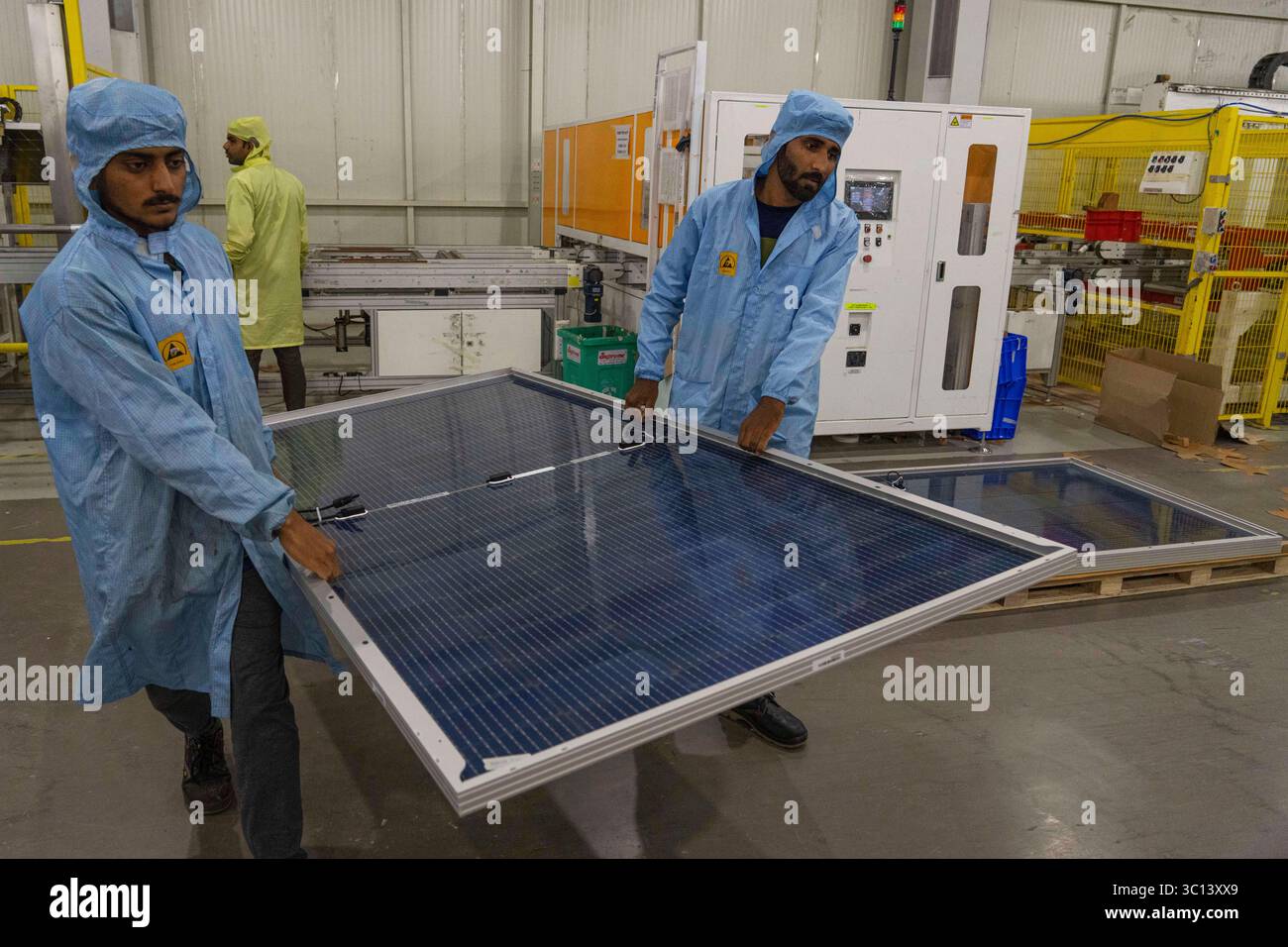 FILE - Employees carry solar panels at the Adani New Industries Limited ...