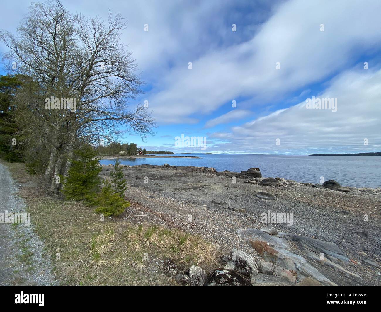 A beautiful coastal landscape with a rocky beach and a bright, cloudy sky. - Smartphone Captured Stock Image