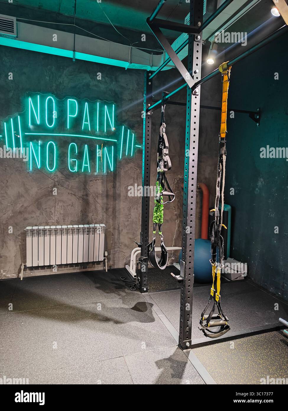 Almaty, Kazakhstan - February 03, 2025: TRX gym features neon sign No Pain No Gain with fitness equipment in modern interior Stock Photo