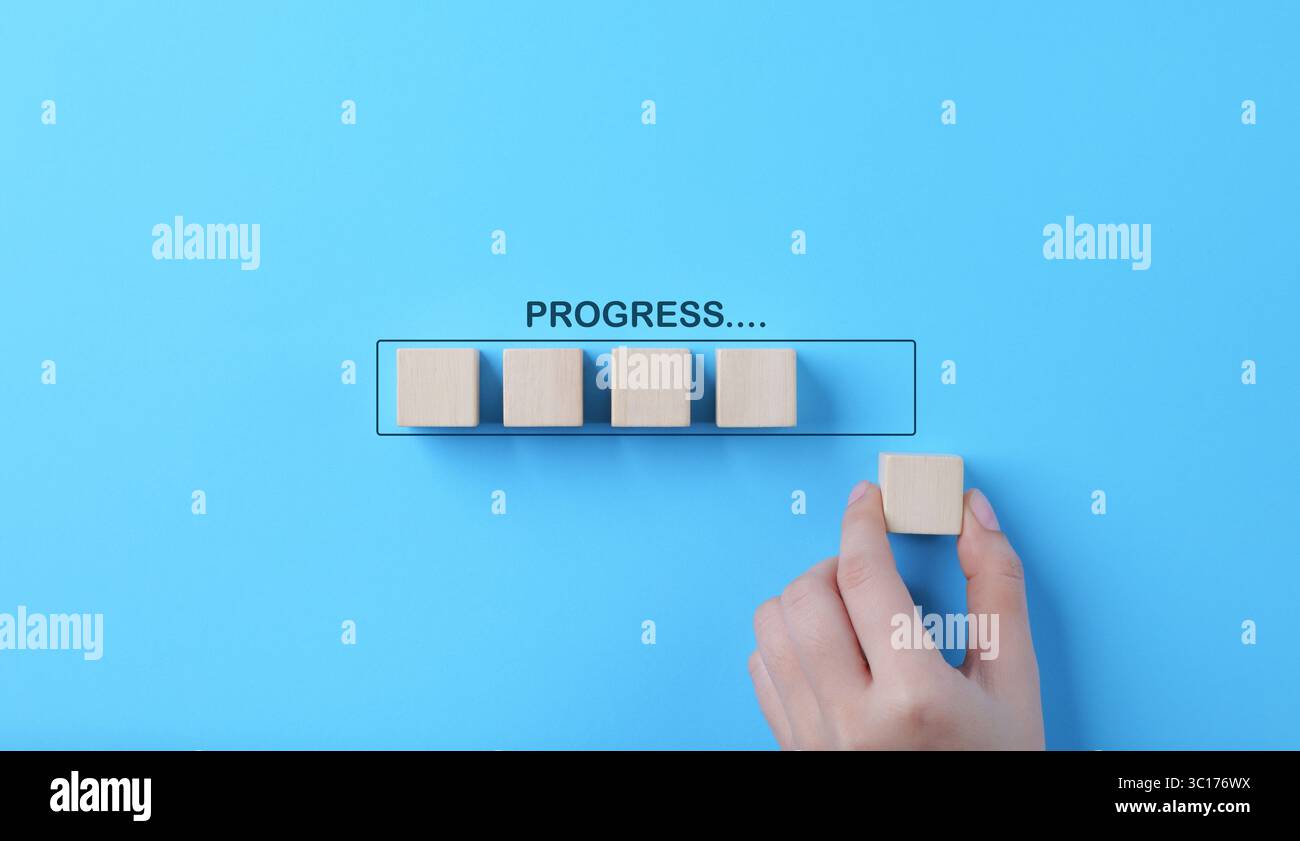 Hand places wooden cubes arranged in row on blue background. with the word progress. in progress, work loading bar, achievement business project plan, Stock Photo