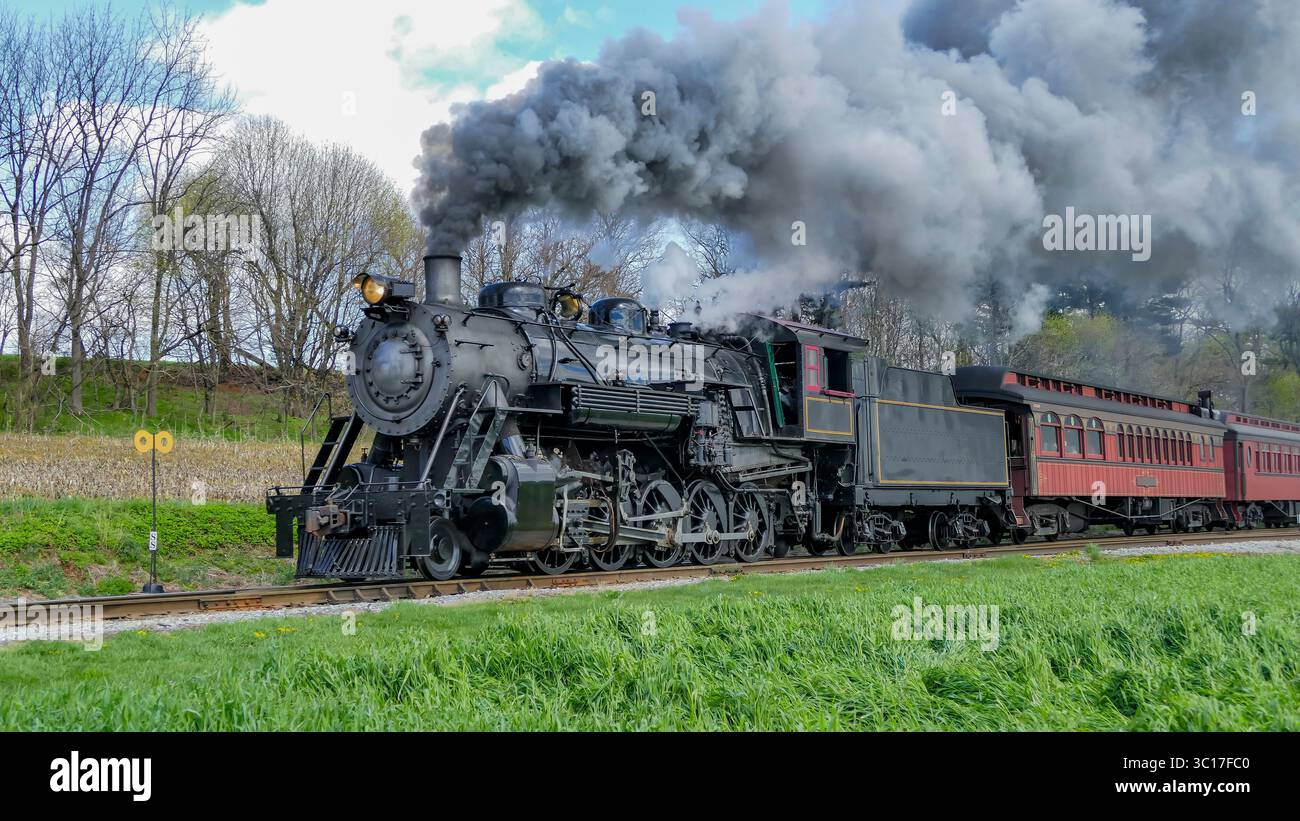 Puff Along A vintage steam locomotive puffs black smoke as it moves along a ...