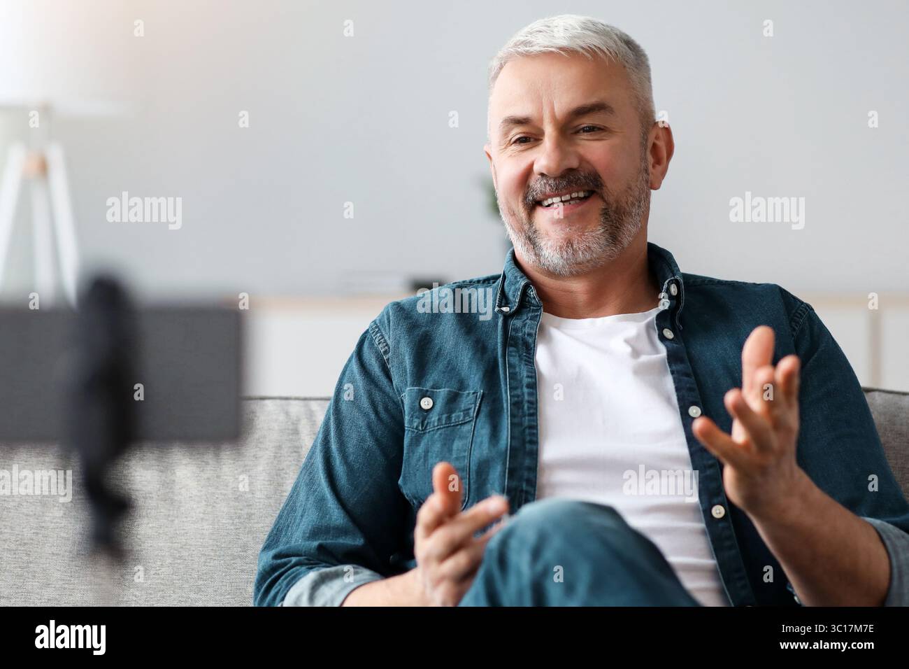Happy handsome senior man broadcasting from home Stock Photo
