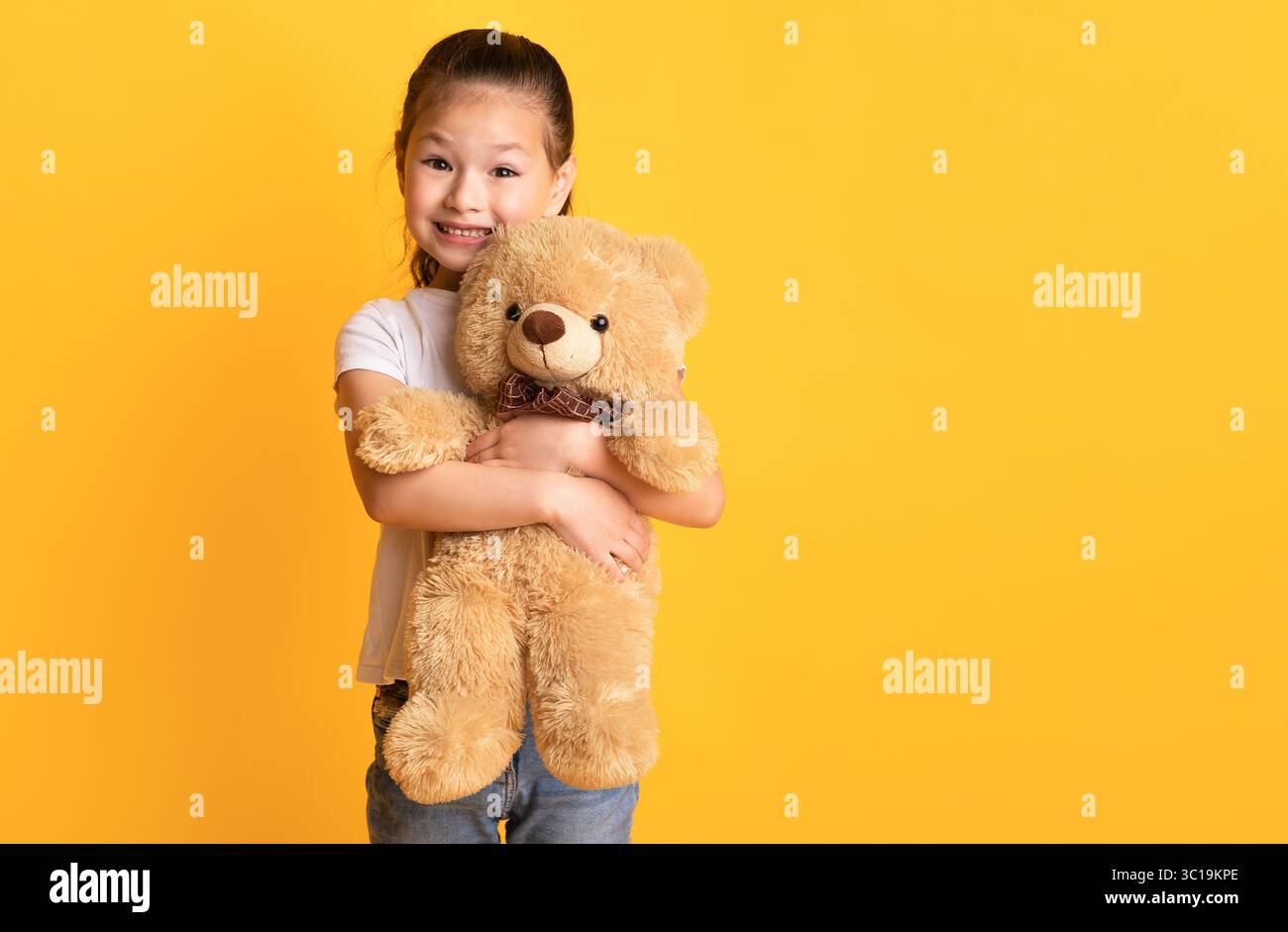 Little asian girl standing and holding teddy bear Stock Photo - Alamy