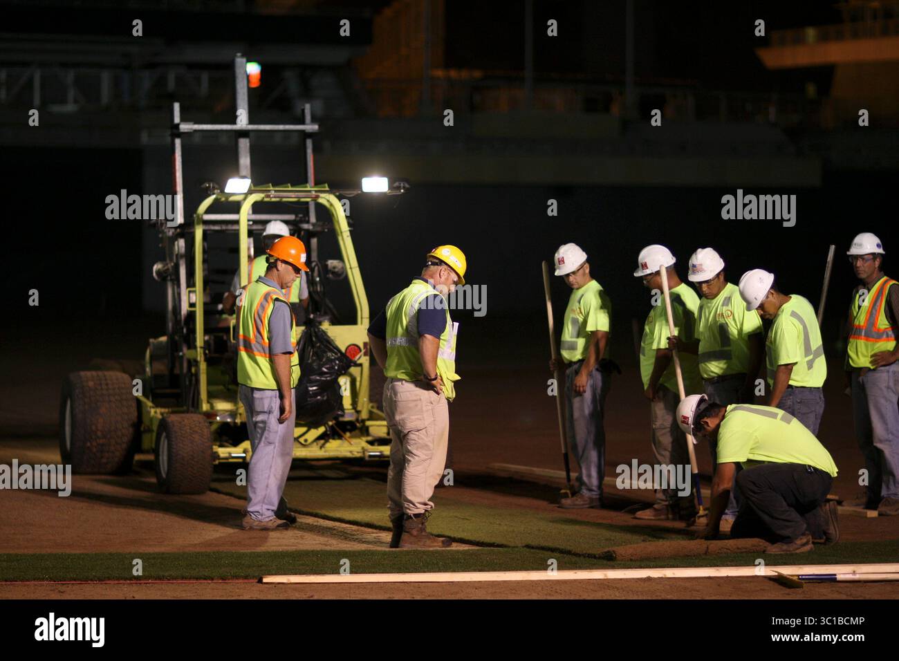 NEAPOLIS - 8/24/09 - The first field grass was installed Monday night down the left field line at Target Field. The sod was harvested starting at 4 a.m. Monday morning at Graff's Turf Farms in Fort Morgan, CO. The 4' wide rolls of turf were then loaded onto refrigerated trucks and driven straight to Minneapolis for installation, which began at about 10:30 p.m. The grass, trimmed to 5/8'', was planted a year ago and was grown in soil that is 90% sand. IN THIS PHOTO: A worker trimmed the second and third strips of turf installed in left field Monday night at Target Field in Minneapolis. (Credit Stock Photo