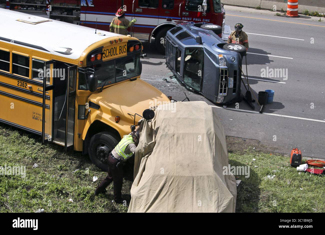 May 30, 2012 - St. Paul, MN, U.S. - A law-enforcement officer looks inside  of a van covered beneath a tarp at the scene of a bus and three car  accident Wednesday,
